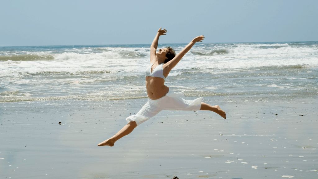 Woman Celebrating dancing on the beach